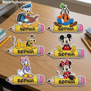 Può includere: Sei etichette decorative a forma di matita con i personaggi Disney Paperino, Pippo, Pluto, Topolino, Paperina e Minni. Ogni grafica di matita gialla presenta il nome SOPHIA stampato in lettere maiuscole nere sul lato.