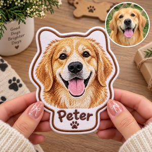May include: A custom embroidered patch featuring a golden retriever dog's face with a brown border. Below the dog's head, the name Peter is stitched in brown thread above a small brown paw print icon. The patch is white with brown trim.