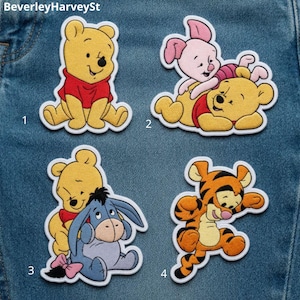 May include: Four embroidered patches featuring Winnie the Pooh characters. Patch 1 shows Pooh sitting. Patch 2 shows Piglet on Pooh's back. Patch 3 shows Pooh with Eeyore. Patch 4 shows Tigger jumping. Each patch has a white border and is numbered 1 through 4.