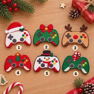 May include: Six embroidered patches shaped like video game controllers with festive themes. Designs include a Santa hat, a red bow, reindeer antlers, a Christmas tree, a snowman, and a candy cane. Each patch is numbered one through six.
