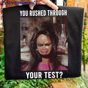 May include: A white ceramic mug with a black handle and the text "But First, Coffee" in a bold, black font. The mug is set against a neutral background, highlighting its simple design.