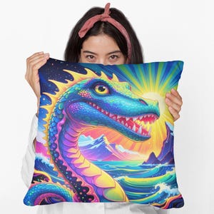 May include: A colorful decorative pillow featuring a vibrant dragon illustration. The dragon is depicted with blue, green, and yellow scales, set against a backdrop of a sunset over a sea with mountains. The pillow is square.