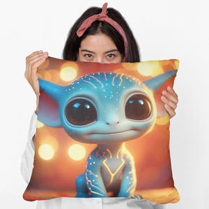 May include: A blue and white cartoon creature with large eyes on a pillow. The pillow has a background of orange and yellow lights.
