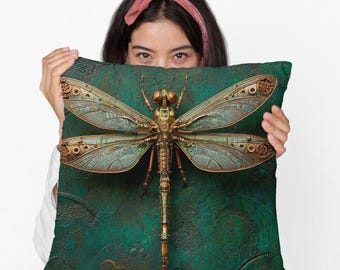 May include: Cushion with a steampunk dragonfly design. The dragonfly is detailed with metallic gold and bronze elements, and mechanical features. The background is a textured teal green.