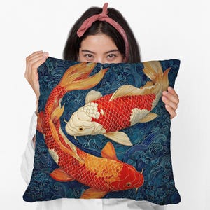 May include: Decorative square pillow featuring a vibrant design of two koi fish in shades of red, orange, and white, set against a deep blue background with wave patterns. The pillow has a soft, textured appearance.
