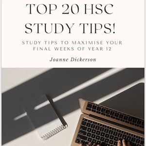 May include: A person's hands typing on a gold laptop computer with a black keyboard. A notebook with the word "NOTES" written on it and a gold pen are on a white surface. The image is lit by natural light, casting shadows on the surface.