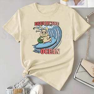 Wielkanocna koszulka z króliczkiem surfingowym Wielkanocna koszulka dla dorosłych Unisex Miłośnik króliczków Prezent na świąteczną koszulkę Wielkanocny koszyk Jajko Deska surfingowa Śmieszne koszulki