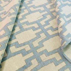 Top-down view of a modern handwoven rug highlighting its repeating geometric motifs and balanced color contrast. Crafted from premium wool, this flatweave area rug offers long-lasting quality and everyday comfort. The neutral beige base with soft blue accents suits minimalist and modern interiors. Ideal for living rooms, bedrooms, or open spaces, this handmade rug adds warmth, texture, and contemporary style