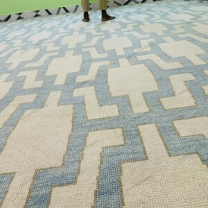 Side angle image showing the rug’s fringe detailing and clean woven finish. This handmade geometric rug features a durable flatweave structure and premium wool material. Its modern abstract design complements Scandinavian, coastal, and minimalist décor styles. Perfect as a living room or bedroom rug, this area rug brings artisan craftsmanship, subtle elegance, and timeless appeal to modern home décor settings.