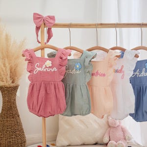 Bubbelsparkdräkt i ekologisk muslin med handsydda, upphöjda, personliga namn och matchande hårrosetter för nyfödd flicka