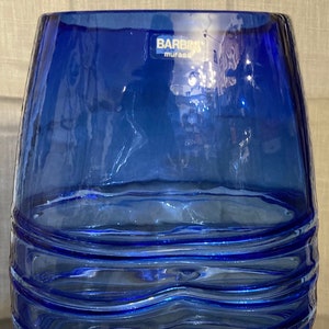 May include: A cobalt blue glass vase with a wavy, textured design. The vase is made by Barbin, Murano.