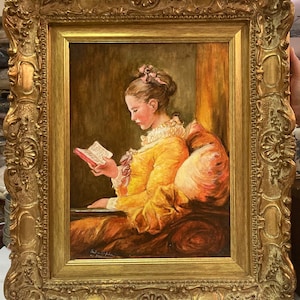 May include: A framed oil painting of a young girl in a yellow dress reading a book. The girl is sitting in a chair with a pink pillow. The painting is set against a warm, golden background.