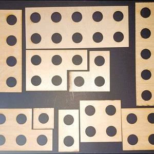 May include: A set of nine wooden pieces with circular cutouts. The pieces are arranged in a pattern on a black background.