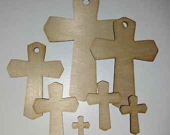 May include: A set of six unfinished wooden crosses of varying sizes. The crosses are made of light brown wood and have a smooth surface. They are perfect for crafting and decorating.