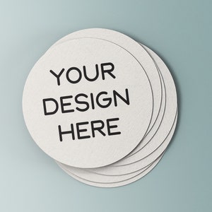 May include: A stack of white round paper coasters with the text "YOUR DESIGN HERE" printed in black.