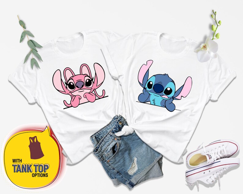 Op de afbeelding: Twee witte T-shirts met een cartoon afbeelding van Stitch en Angel uit de Disney-film Lilo & Stitch. De shirts liggen op een witte achtergrond met een blauwe jeans en witte sneakers.