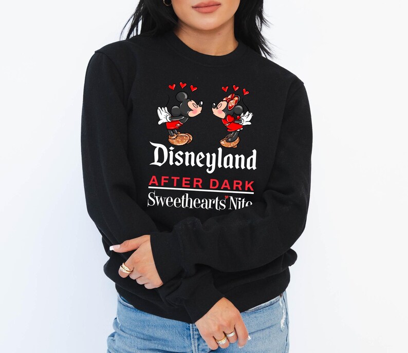 Puede incluir: Sudadera negra con un gr&aacute;fico de Mickey Mouse y Minnie Mouse bes&aacute;ndose. El texto "Disneyland After Dark Sweethearts Nite" est&aacute; impreso en la sudadera.
