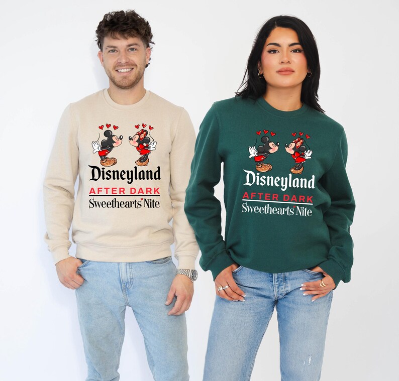 Puede incluir: Una pareja lleva sudaderas a juego con un gr&aacute;fico de Mickey Mouse y Minnie Mouse. Las sudaderas son beige y verde y dicen "Disneyland After Dark Sweethearts Nite".
