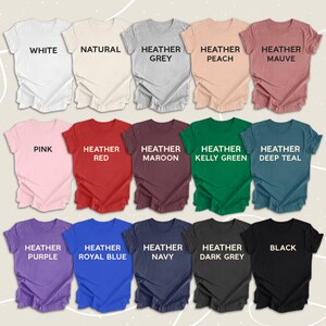 May include: A selection of t-shirts in various colours, including white, natural, heather grey, heather peach, heather mauve, pink, heather red, heather maroon, heather kelly green, heather teal, heather purple, heather royal blue, heather navy, heather dark grey, and black.