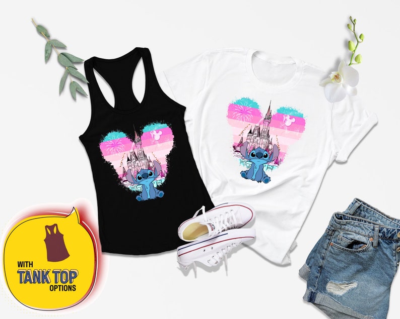 Op de afbeelding: Een zwart tanktop en een wit t-shirt met een blauw Stitch-personage voor een roze en blauw kasteel met vuurwerk. De tekst "WITH TANK TOP OPTIONS" staat in een gele spraakballon.