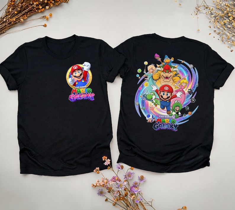 Peut inclure: Deux t-shirts noirs avec des graphiques du jeu vid&eacute;o Super Mario Galaxy. Un t-shirt a un graphisme avant de Mario dans un cercle dor&eacute; avec le titre du jeu. L'autre t-shirt a un grand graphisme de Mario et d'autres personnages.