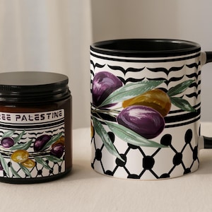 May include: A brown jar with a black lid and a mug with a black handle. Both items feature a design of olives and the text "FREE PALESTINE". The mug has a black and white geometric pattern.