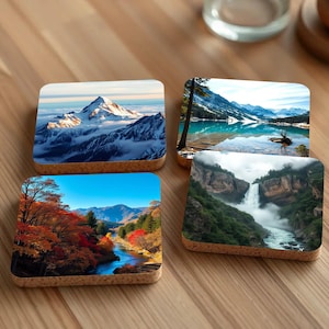 May include: Four cork coasters featuring different nature scenes. The first coaster depicts a snowy mountain peak with a blue sky. The second coaster shows a lake with a mountain range in the background. The third coaster has a waterfall cascading down a rocky cliff. The fourth coaster shows a river flowing through a forest with red and orange leaves.