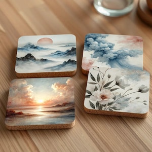 Puede incluir: Cuatro posavasos cuadrados de corcho con diferentes diseños de acuarela. Los posavasos presentan una puesta de sol sobre una masa de agua, una cordillera con un sol rojo, un diseño floral con flores blancas y un cielo azul con nubes.