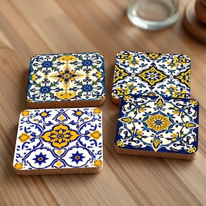 Op de afbeelding: Vier vierkante kurk onderzetters met een geometrisch patroon in blauw, geel en wit. De onderzetters hebben een traditioneel Portugees tegelontwerp.
