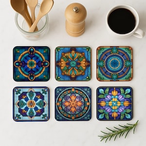 Op de afbeelding: Set van zes vierkante onderzetters met ingewikkelde glas-in-loodontwerpen. Elke onderzetter heeft een ander patroon in tinten blauw, groen, geel en paars.