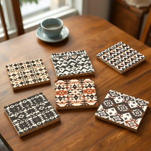 Może przedstawiać: Sześć podkładek pod kubki z geometrycznymi wzorami w kolorze czarnym, białym, brązowym i pomarańczowym. Podkładki są wykonane z drewna i mają korkową podstawę.