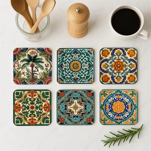 Op de afbeelding: Zes vierkante onderzetters met kleurrijke, ingewikkelde bloemen- en geometrische patronen. De onderzetters hebben verschillende ontwerpen, waaronder een palmboom en andere bloemmotieven in groen, blauw, oranje en geel. De onderzetters zijn gerangschikt op een wit oppervlak.