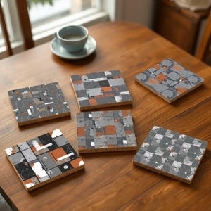 May include: Six different coasters with geometric patterns in shades of gray and orange. The coasters are made of cork and have a slightly textured surface.