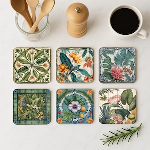 Peut inclure: Ensemble de six dessous de verre carrés avec des motifs botaniques. Chaque dessous de verre présente un motif floral ou de feuilles unique dans les tons de vert, bleu, jaune et rose. Les dessous de verre sont disposés sur une surface blanche.