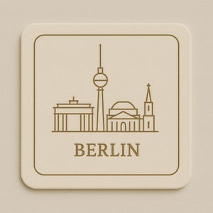 Könnte beinhalten: Ein quadratischer, beigefarbener Untersetzer mit einer braunen Umrisszeichnung von Berliner Wahrzeichen, darunter das Brandenburger Tor und der Fernsehturm. Das Wort "BERLIN" ist darunter braun gedruckt.