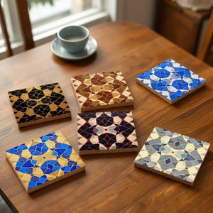 May include: Six different patterned coasters with geometric designs in shades of blue, gold, black, white, red, and brown. The coasters are made of cork and have a square shape.