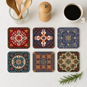 Könnte beinhalten: Sechs quadratische Untersetzer mit aufwendigen, farbenfrohen Mustern, die an Orientteppiche erinnern. Die Untersetzer weisen Designs in Rot, Blau, Orange und Gold mit floralen und geometrischen Motiven auf. Eine Tasse Kaffee, Holzlöffel und eine Pfeffermühle sind ebenfalls zu sehen.