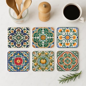May include: Six square coasters with detailed floral and geometric patterns in blue, green, orange, and yellow. A cup of coffee, wooden spoons, and a pepper grinder are also visible. The coasters are likely 10 cm x 10 cm.