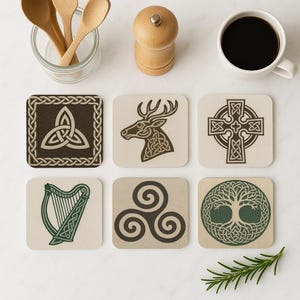 May include: Set of six square coasters with Celtic knot designs. The coasters feature various symbols, including a deer head, a Celtic cross, a harp, and a tree of life. Colors include brown, green, and beige.