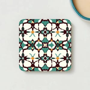 Coaster A with a bold teal-and-red floral pattern reminiscent of historic Iznik ceramics, showcasing a cork backing.”