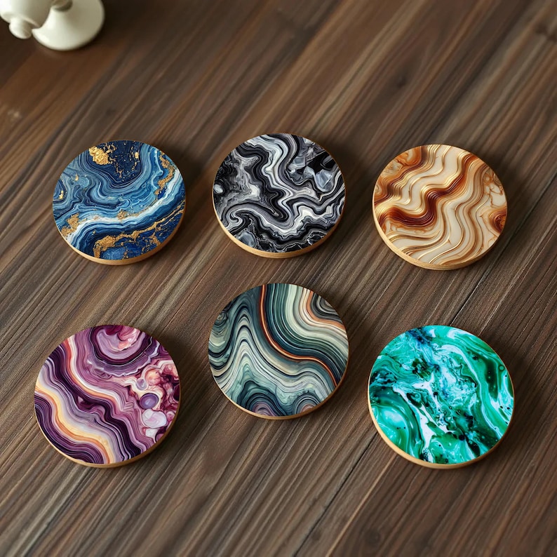 Six round coasters with mesmerizing agate and marble-inspired swirl designs in shades of blue, black, gold, green, and purple, displayed on a wooden table.
