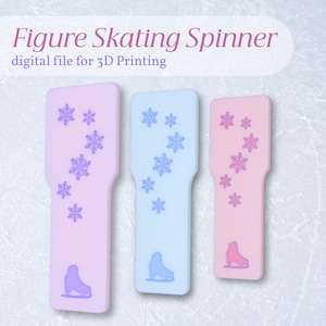 May include: Three figure skating spinners in pink and blue, decorated with snowflake patterns and ice skate silhouettes. The text "Figure Skating Spinner" and "digital file for 3D Printing" are displayed at the top.
