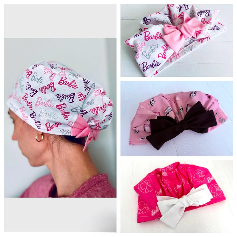May include: A set of three pink and white fabric headbands with a Barbie logo print. The headbands have a bow on top.