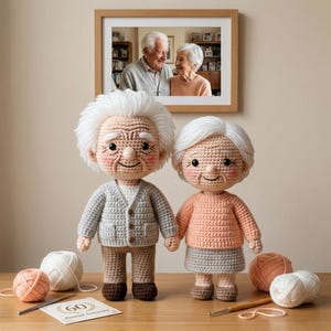May include: Two crocheted dolls of an elderly couple, with white hair and rosy cheeks, stand side-by-side. The male doll wears a gray cardigan, while the female doll wears a peach sweater and gray skirt. A framed photo of an elderly couple hangs above them. A card reads "60th Diamond Anniversary."