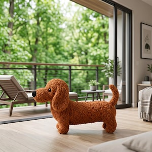 May include: A plush, textured, rust-colored dachshund figurine with a black nose and dark eyes. The dog stands on four short legs with a long body and a curved tail, crafted from a soft, curly fabric material that gives it a fuzzy appearance.