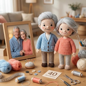 May include: A wooden framed photo of an elderly couple stands next to two crocheted dolls of an elderly couple. The dolls are wearing a blue cardigan and a pink sweater. Sewing supplies and yarn are on the table, along with a card that says "40 Anniversary".
