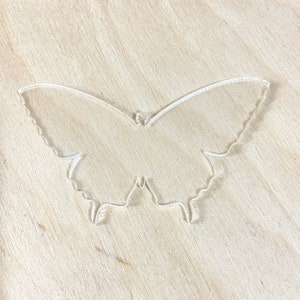 May include: A clear plastic butterfly cutout, ideal for crafting projects.