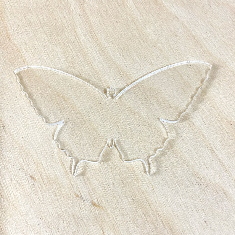 May include: A clear plastic butterfly cutout, ideal for crafting projects.