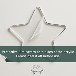 May include: A clear acrylic star with a protective film covering both sides. The film is partially peeled back, revealing the clear acrylic underneath. The text "Protective film covers both sides of the acrylic. Please peel it off before use." is visible below the star.