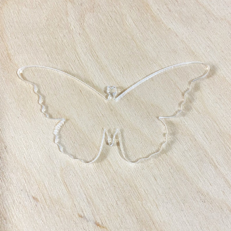 May include: A clear acrylic butterfly cutout, ideal for crafting or home decor.